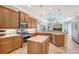 Charming kitchen featuring stainless steel appliances, a center island, and an open view to the living room at 6539 Flycatcher Ln, Lakewood Ranch, FL 34202