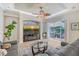 Bright living room with access to the outdoor patio and featuring a ceiling fan and large television at 6539 Flycatcher Ln, Lakewood Ranch, FL 34202