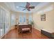 Bright main bedroom with a ceiling fan, wood floors, and multiple windows for natural light at 6539 Flycatcher Ln, Lakewood Ranch, FL 34202