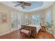 Serene main bedroom featuring wood flooring, a ceiling fan, and an abundance of natural light from plantation-shuttered windows at 6539 Flycatcher Ln, Lakewood Ranch, FL 34202