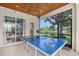 Screened-in patio with ping pong table and serene water views at 6539 Flycatcher Ln, Lakewood Ranch, FL 34202