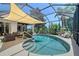 Screened-in pool area featuring a sunshade, patio furniture, and lush landscaping at 6539 Flycatcher Ln, Lakewood Ranch, FL 34202