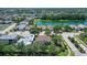Aerial view of house nestled in a neighborhood with lake views and mature trees at 6605 38Th E Ln, Sarasota, FL 34243