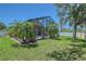 Backyard pool with screened enclosure, tropical landscaping, and well-maintained lawn at 6605 38Th E Ln, Sarasota, FL 34243