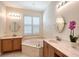 Bathroom with dual sinks, soaking tub, plantation shutters and lots of natural light at 6605 38Th E Ln, Sarasota, FL 34243