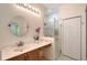 Bright bathroom features walk-in shower, white cabinets, granite countertop, and round mirror at 6605 38Th E Ln, Sarasota, FL 34243