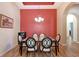 Formal dining room with elegant chandelier and bright red accent wall at 6605 38Th E Ln, Sarasota, FL 34243