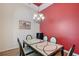 Dining area featuring decorative table with chandelier and bright red accent wall at 6605 38Th E Ln, Sarasota, FL 34243