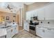 Bright kitchen features white cabinetry, granite countertops, stainless steel appliances, and wood-look tile flooring at 6605 38Th E Ln, Sarasota, FL 34243