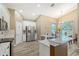 Open-concept kitchen with stainless steel refrigerator, white cabinets, granite counters, and breakfast bar at 6605 38Th E Ln, Sarasota, FL 34243