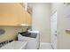 Bright laundry room includes a utility sink, washer and dryer, and cabinet storage at 6605 38Th E Ln, Sarasota, FL 34243