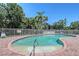 Community pool surrounded by lush tropical landscaping and secure fencing for added privacy at 6605 38Th E Ln, Sarasota, FL 34243
