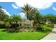 Landscaped community entrance sign with palm trees at 6605 38Th E Ln, Sarasota, FL 34243