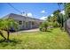 Expansive green backyard features lush lawn, trees, and covered patio at 6931 Magellan Way, Sarasota, FL 34243