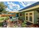 Outdoor patio area with a table and chairs, an umbrella, and a lush green lawn at 6931 Magellan Way, Sarasota, FL 34243