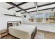 Well-lit bedroom with exposed ceiling beams, a comfortable bed, and large windows at 6931 Magellan Way, Sarasota, FL 34243
