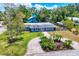 Manicured lawn, tropical landscaping, and a paver driveway create great curb appeal at 6931 Magellan Way, Sarasota, FL 34243