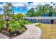 A winding paver driveway leads to this charming home with lush, tropical landscaping at 6931 Magellan Way, Sarasota, FL 34243