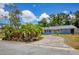 Charming single-story home featuring mature landscaping and a brick-paved driveway at 6931 Magellan Way, Sarasota, FL 34243