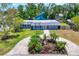 Beautiful exterior with tropical landscaping, winding paver driveway, and lush green lawn at 6931 Magellan Way, Sarasota, FL 34243