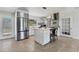 Open kitchen design features stainless steel appliances, island seating, and tile flooring at 6931 Magellan Way, Sarasota, FL 34243