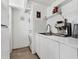 All-white laundry area featuring a stacked washer/dryer unit, white cabinets, and a modern sink at 6931 Magellan Way, Sarasota, FL 34243