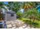 A modern storage shed sits on a stone tile pad in a well-maintained yard at 6931 Magellan Way, Sarasota, FL 34243