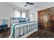 Charming bedroom with a blue metal bedframe, wooden floors, and matching wooden closet doors at 720 37Th W St, Bradenton, FL 34205