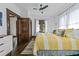 Bedroom featuring dark wood floors, white walls, ceiling fan, and stylish yellow and white bedding at 720 37Th W St, Bradenton, FL 34205