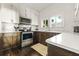 Kitchen featuring stainless steel appliances, marble backsplash and white countertops on dark wood cabinets at 720 37Th W St, Bradenton, FL 34205