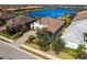 Aerial view of a beautiful home with a lake view and a well-manicured lawn at 7208 Prestbury Cir, Bradenton, FL 34202