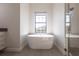 Elegant bathroom showcasing a standalone tub beneath a window, next to a glass-enclosed shower at 7208 Prestbury Cir, Bradenton, FL 34202