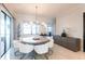 Bright dining room features a round table with white chairs, modern chandelier, and sliding glass doors at 7208 Prestbury Cir, Bradenton, FL 34202
