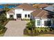 Elegant home exterior with a paver driveway, manicured landscaping, and a stately entrance at 7208 Prestbury Cir, Bradenton, FL 34202