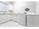 Clean, functional laundry room with washer, dryer, and storage at 7208 Prestbury Cir, Bradenton, FL 34202