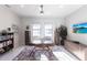 Bright office with large desk, TV, ceiling fan, rug, and built-in shelving and cabinets at 7208 Prestbury Cir, Bradenton, FL 34202