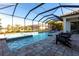 An enclosed pool area with spa includes patio chairs and brick-paver decking at 7208 Prestbury Cir, Bradenton, FL 34202