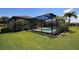 This backyard offers a screened-in pool and manicured lawn at 7311 64Th St E, Palmetto, FL 34221