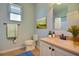 Neutral bathroom with a modern vanity and fixtures, a decorative print, and bright window at 7311 64Th St E, Palmetto, FL 34221