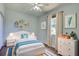Bright bedroom with a white bed frame, matching dressers, a ceiling fan, and a large window at 7311 64Th St E, Palmetto, FL 34221