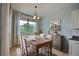 Sunlit dining room boasts a wood table, linen chairs, large window and a scenic painting at 7311 64Th St E, Palmetto, FL 34221