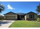 Inviting single-story home featuring a well-manicured lawn, two-car garage, and charming stone accents at 7311 64Th St E, Palmetto, FL 34221