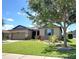 Charming single-story home featuring manicured lawn and garden beds surrounding the property at 7311 64Th St E, Palmetto, FL 34221