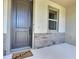 Inviting front door with stone accents, a 'Welcome' mat, and ample natural light from the adjacent window at 7311 64Th St E, Palmetto, FL 34221
