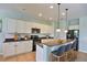 Bright eat-in kitchen features white cabinets, black appliances, pendant lights, granite countertops and seating at 7311 64Th St E, Palmetto, FL 34221