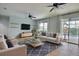 Comfortable living room featuring ceiling fans, a modern entertainment center, and sliding glass doors to the pool at 7311 64Th St E, Palmetto, FL 34221