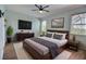 Relaxing main bedroom with a ceiling fan, a large window, a modern dresser and a comfortable bed at 7311 64Th St E, Palmetto, FL 34221