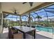 Screened-in outdoor dining area overlooking a sparkling pool and lush landscaping at 7311 64Th St E, Palmetto, FL 34221