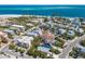 High-angle aerial view of beautiful beach homes with lush landscaping and views of the ocean at 799 Jacaranda Rd, Anna Maria, FL 34216
