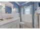 Bathroom with blue accent wall, walk-in shower, and marble countertops at 799 Jacaranda Rd, Anna Maria, FL 34216